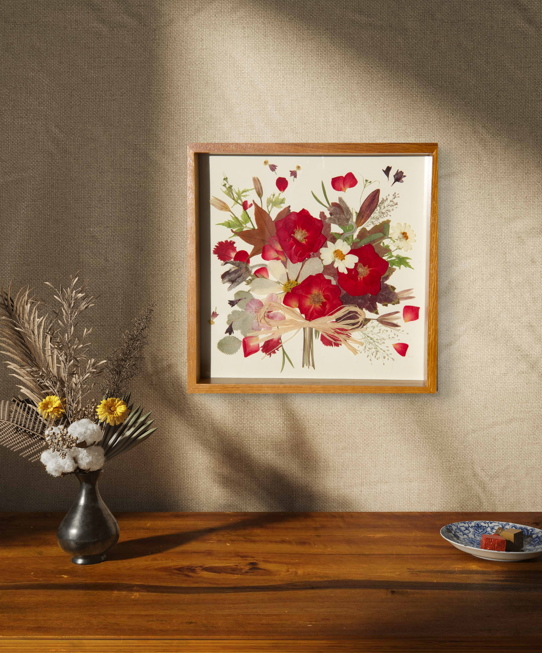 flower bouquet shaped red theme pressed flower frame art hanging above wood desk