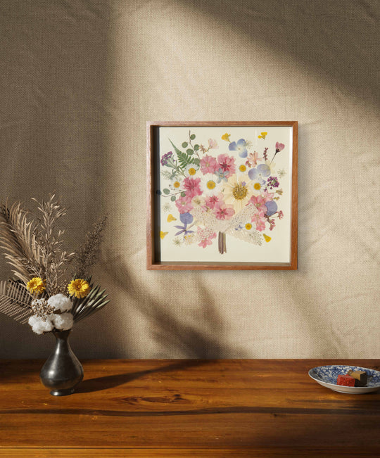 flower bouquet shaped pink theme pressed flower frame art hanging above wood desk