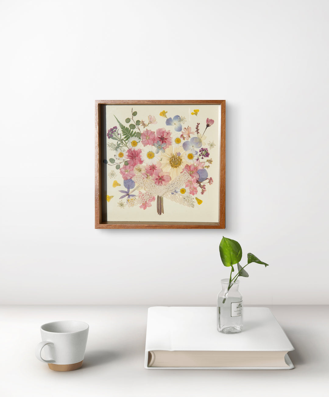 flower bouquet shaped pink theme pressed flower frame art hanging above white desk