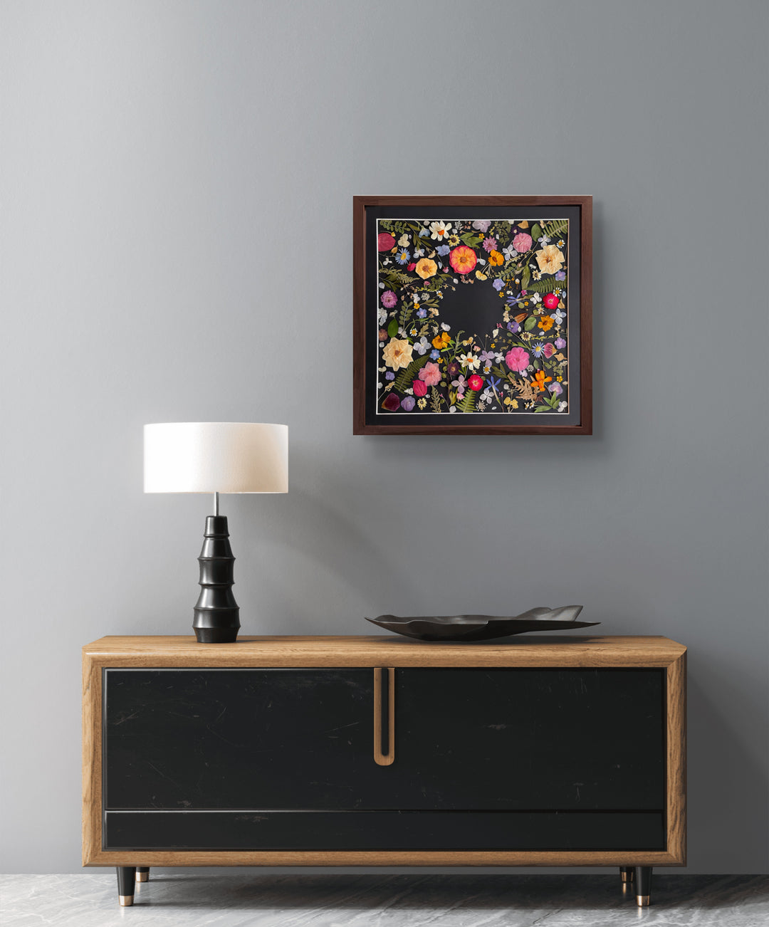 black background pressed flower frame art with flower petals hanging on the living room wall