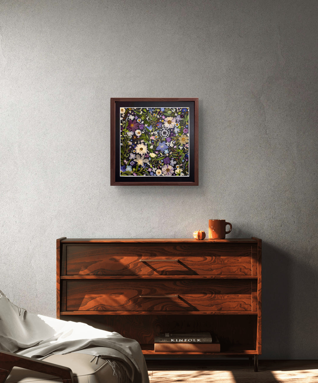 black background pressed flower frame art with flower petals hanging on the wall above a desk