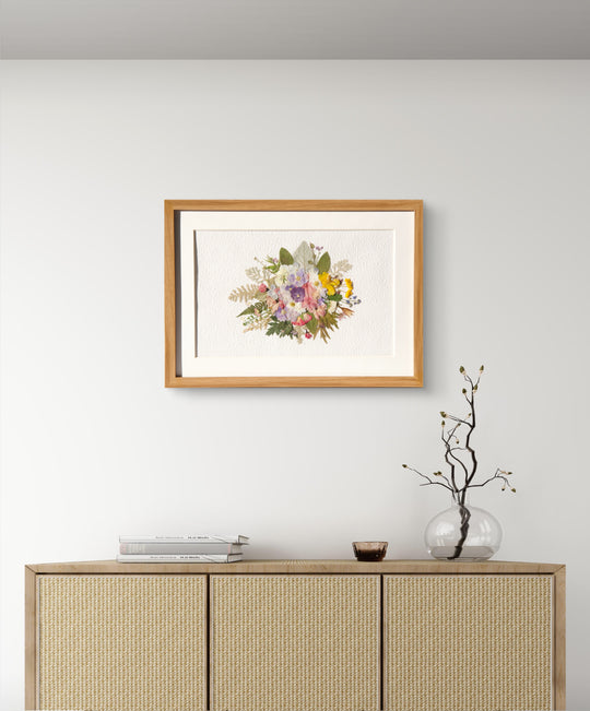 wreath shaped pressed flower frame art hanging on the wall above dresser